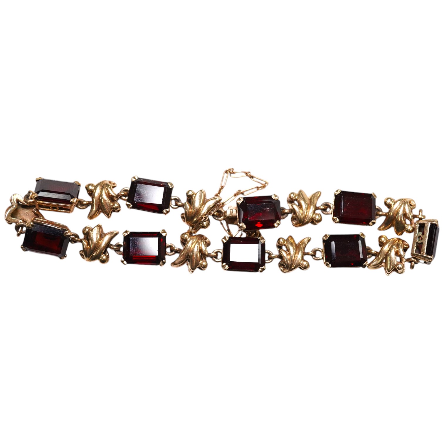 A yellow metal and nine stone emerald cut garnet? set bracelet, 18cm, gross weight 16.5 grams. Condition - fair